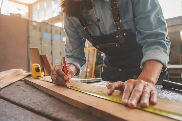 Carpenter measuring wood for Mor Handy carpentry services in Maryland