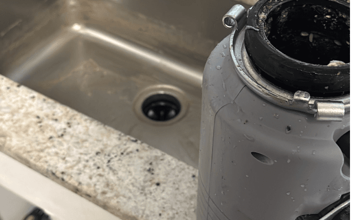 Garbage disposal and sink plumbing before repair Garbage disposal and sink plumbing before repair